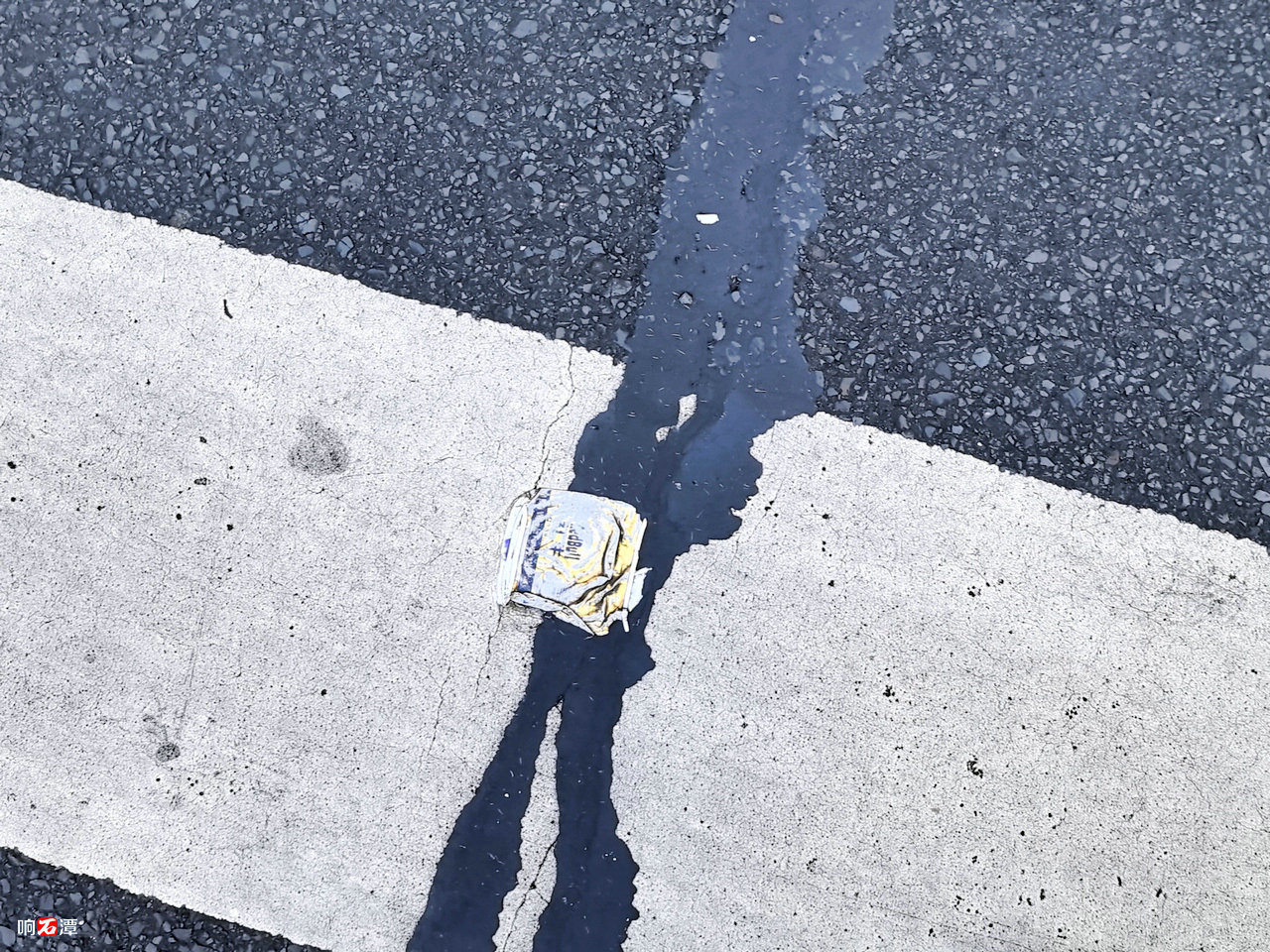 A crushed Red Bull can on the road